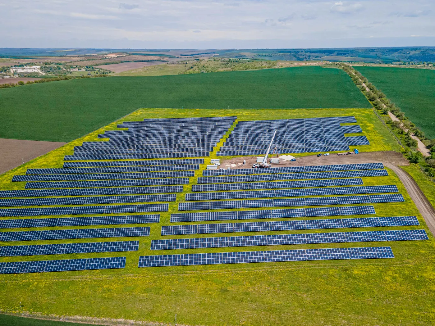 Impianto fotovoltaico fra campi coltivati e filari di alberi